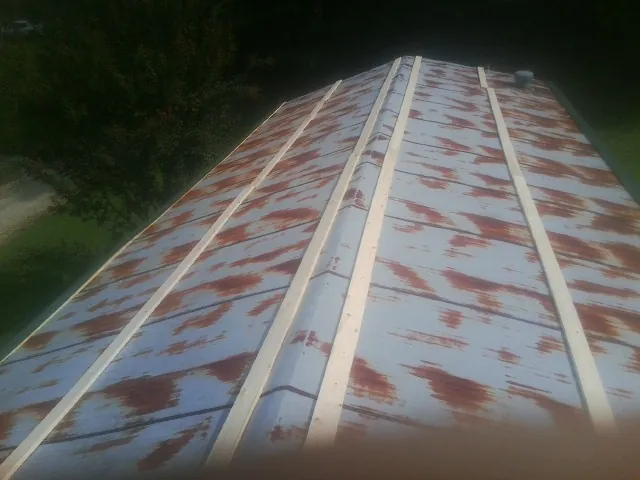 Rusted metal roof panels with new wood purlins before replacement — Storm Damage Roof Repair in Crump by Roofing Brothers