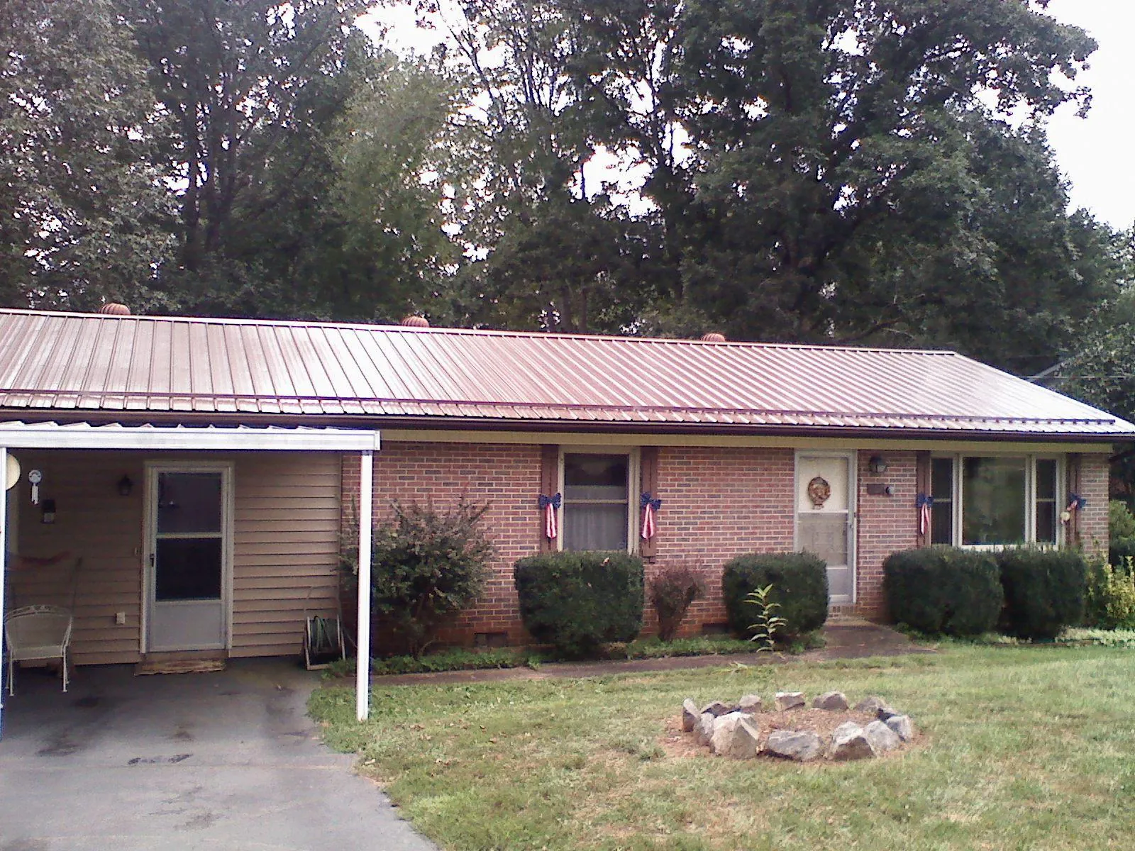 Bronze metal roof and carport on a brick ranch home — Roof Repair work by our crew in Crump